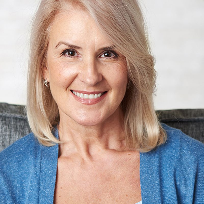 Smiling woman sitting on a couch.